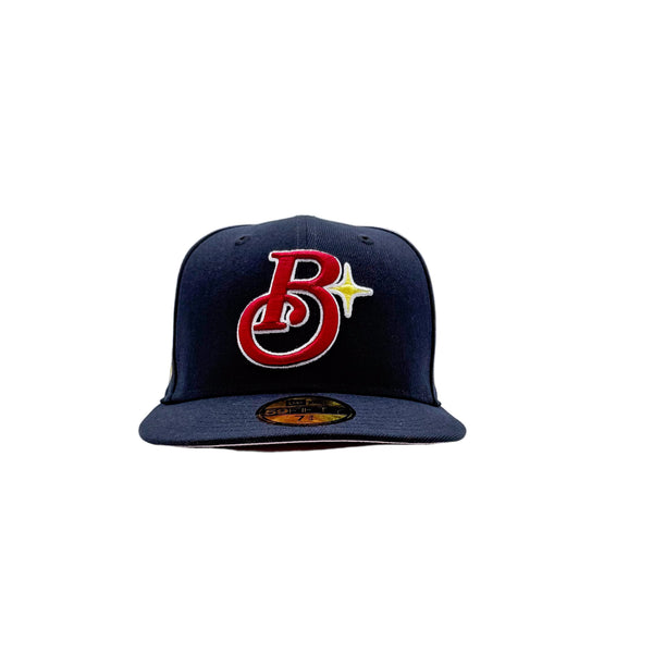 A navy blue baseball cap featuring a red and white embroidered 'Brooklyn Bodega Association' logo with a yellow star on the front, set against a plain light gray background.